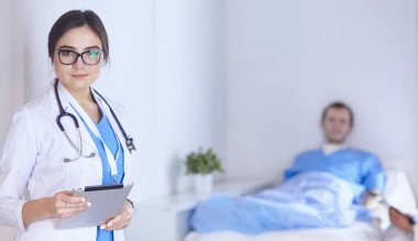 Doktor stetoskop ile yatakta hasta kalp ritmini kontrol