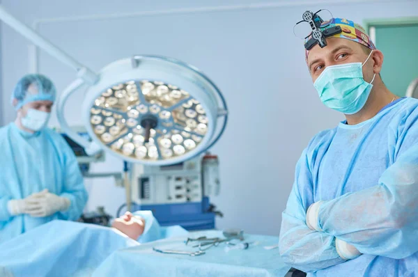Кілька лікарів, що оточують пацієнта на операційному столі під час т — стокове фото