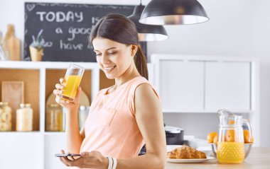 Cep telefonu görünümlü ve cam tutan gülümseyen güzel kadın