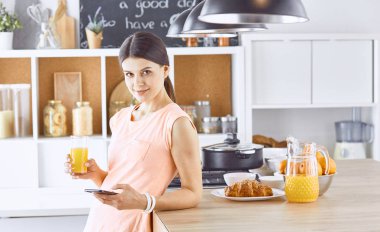 Cep telefonu görünümlü ve cam tutan gülümseyen güzel kadın