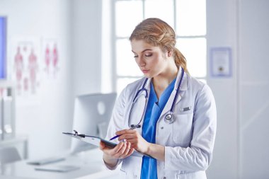 Genç kadın doktor Pano gülümseyerek ile kurulu ile ayakta