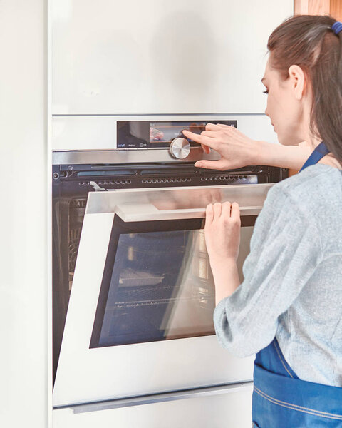 Beautiful woman in the kitchen, waiting with the front of the o