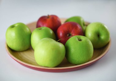 Yeşil ve Kırmızı elma beyaz masaya yatıyor