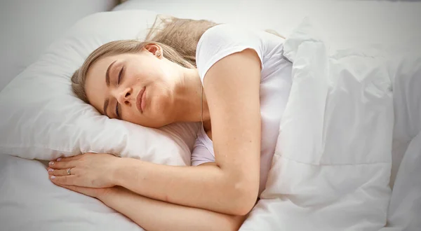 Vacker flicka sover i sovrummet, liggande på sängen — Stockfoto