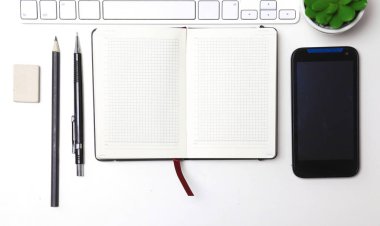 günlük açık, bir bilgisayar ve o masaüstünde bir akıllı telefon