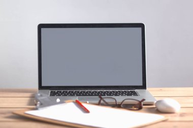 Laptop ahşap bir masada duruyor.