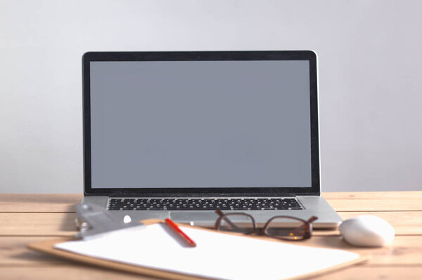 Laptop stands on a wooden table