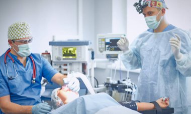 T sırasında ameliyat masasında hasta çevreleyen birkaç doktor