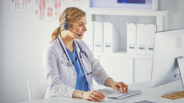 Ofiste kulaklık mutlu gülümseyen genç doktor Portresi