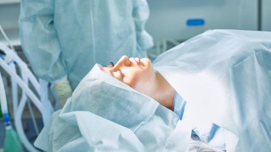 T sırasında ameliyat masasında hasta çevreleyen birkaç doktor