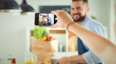 Gülümseyen ve kendinden emin şef büyük mutfakta duruyor.