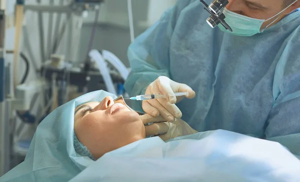 Varios médicos que rodean al paciente en la mesa de operaciones durante t — Foto de Stock