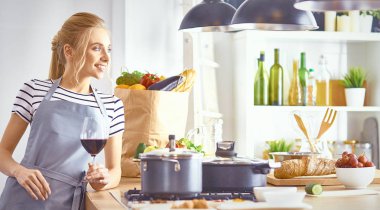 güzel bir kadın mutfakta şarap kırmızı içme