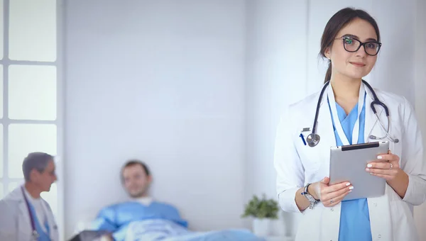 Doktor kontrola tlukot srdce pacienta v posteli s stetoskop — Stock fotografie
