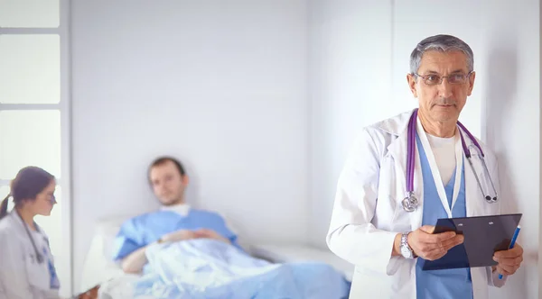 Doktor stetoskop ile yatakta hasta kalp ritmini kontrol — Stok fotoğraf