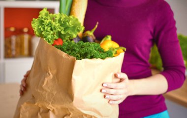 Sağlıklı pozitif mutlu kadın tam bir kağıt alışveriş çantası tutan