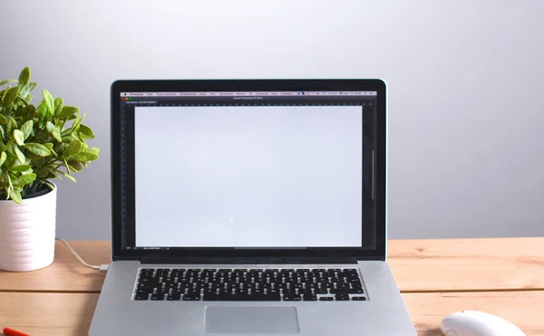 Laptop stands on a wooden table in office