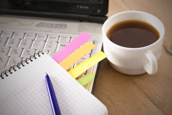 Mesa de escritório com bloco de notas em branco e laptop — Fotografia de Stock