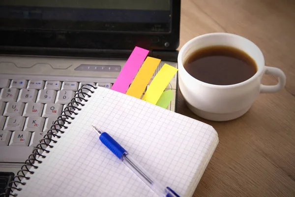 Mesa de escritório com bloco de notas em branco e laptop — Fotografia de Stock
