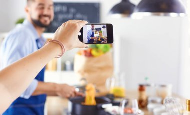 Gülümseyen ve kendinden emin şef büyük mutfakta duruyor.