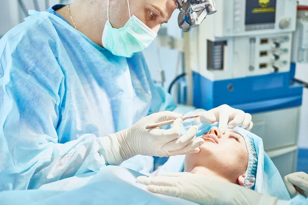 Plusieurs médecins entourant le patient sur la table d'opération pendant t — Photo