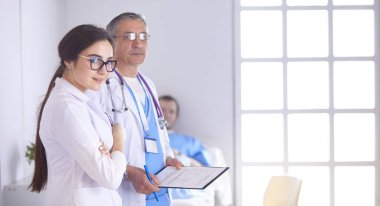 Doktor stetoskop ile yatakta hasta kalp ritmini kontrol