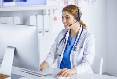 Ofiste kulaklık mutlu gülümseyen genç doktor Portresi