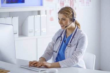 Ofiste kulaklık mutlu gülümseyen genç doktor Portresi