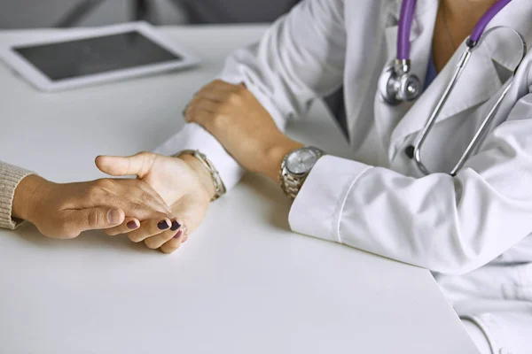 Mujer médico calma paciente y toma de la mano — Foto de Stock