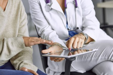 tablette bir hastayla konuşan kadın doktor