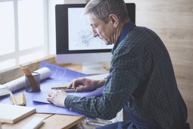 Dizüstü bilgisayarda çalışan ve Proje çizimi mühendis marangoz