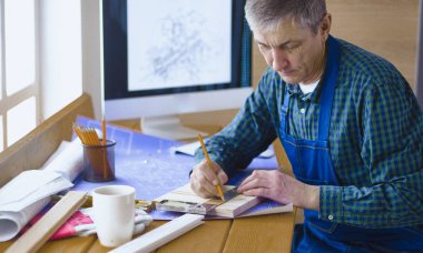 Dizüstü bilgisayarda çalışan ve Proje çizimi mühendis marangoz