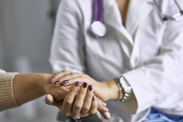 Dokter wanita menenangkan pasien dan berpegangan tangan. — Stok Foto