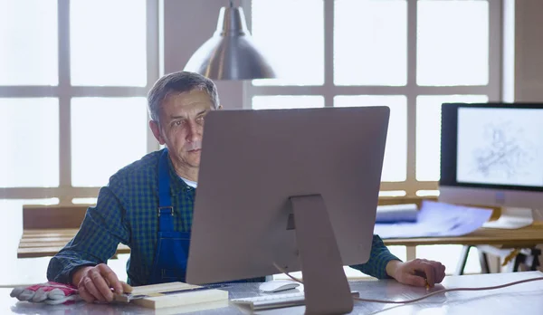 Μηχανικός ξυλουργός εργάζονται για το laptop και σκιαγραφώντας έργου — Φωτογραφία Αρχείου