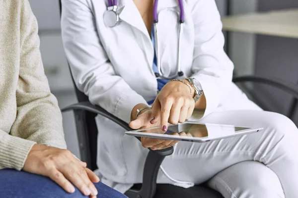 female doctor talking to a patient on a tablet