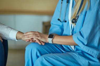 Doktorun eli kadın hastasına güvence veriyor.