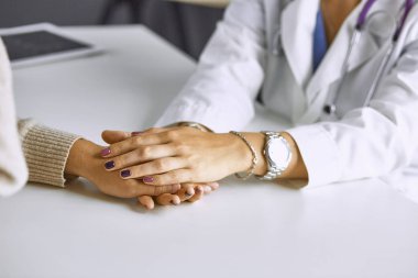 Kadın doktor hastayı sakinleştirir ve elini tutar
