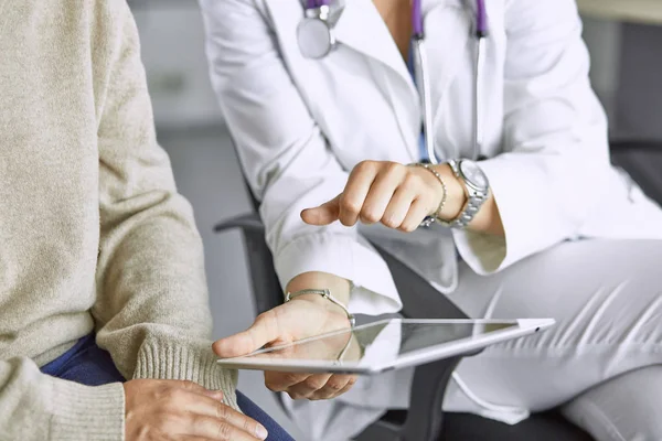 female doctor talking to a patient on a tablet