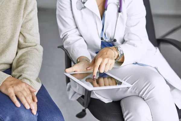 female doctor talking to a patient on a tablet