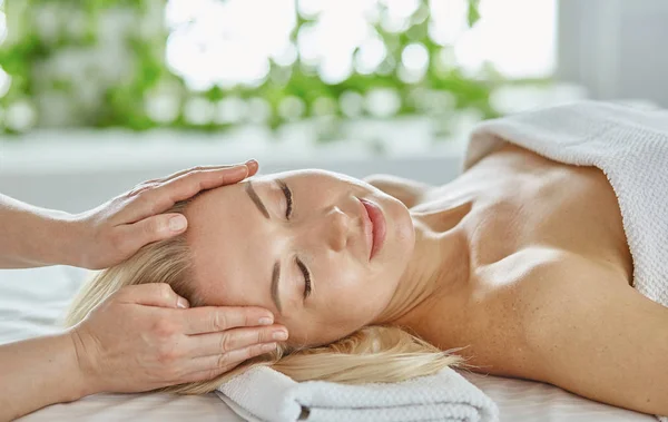 Красива жінка з закритими очима отримує масаж в спа-салоні — стокове фото