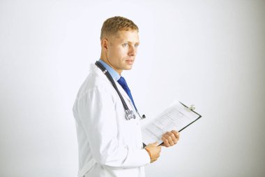 Steteskoplu beyaz önlüklü, kendine güvenen genç bir doktor.