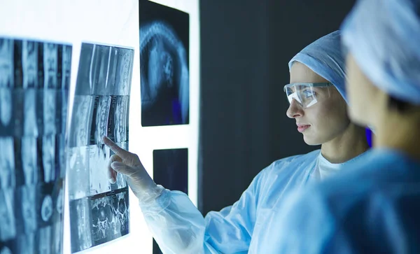 Two female women medical doctors looking at x-rays in a hospital — Stock Photo, Image