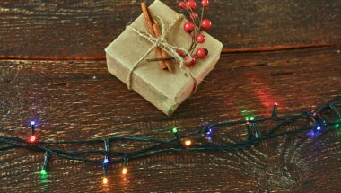 Beyaz doğal ahşap masa üzerinde renkli noel ağacı ışıkları. Alta uzayı kopyala. Düz üst görünüm