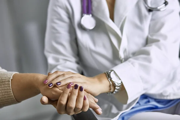 Dokter wanita menenangkan pasien dan berpegangan tangan. — Stok Foto