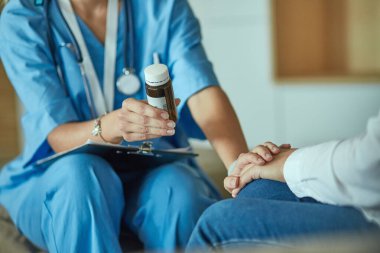 Güzel gülümseyen kadın hap bir şişe doktor t sunuyor
