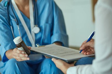 Güzel gülümseyen kadın hap bir şişe doktor t sunuyor