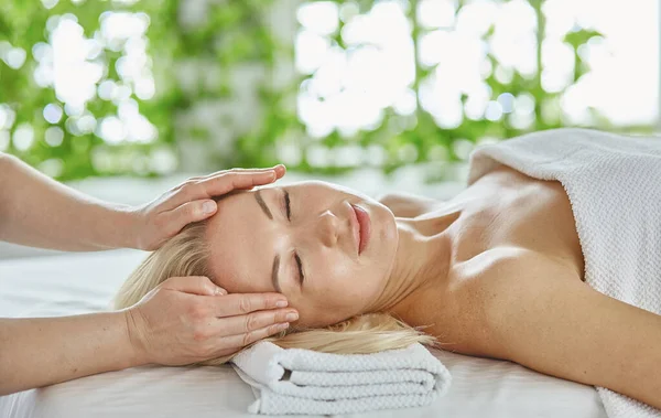 Belle femme aux yeux fermés se faire masser dans le spa s — Photo