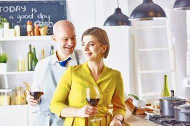 Gülümseyen genç çift mutfakta yemek pişiriyor.