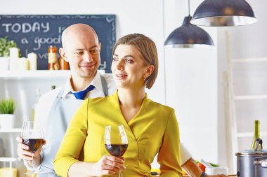 Gülümseyen genç çift mutfakta yemek pişiriyor.