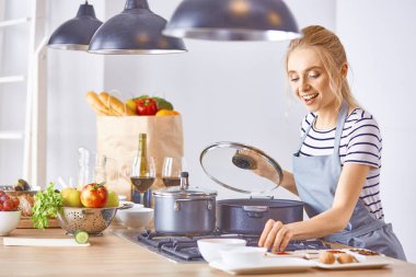 Genç kadın mutfakta yemek pişiriyor. Sağlıklı Yemek